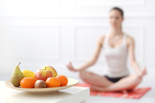 Vrouw mediterend, fruitschaal met fruit op de voorgrond
